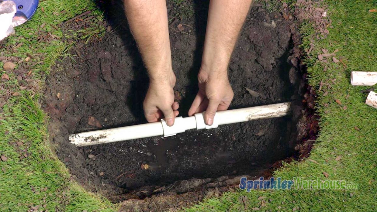 This picture shows a Dawn Kwik Repair Coupling being installed underground to repair PVC pipe.