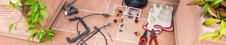 This is a picture of drip irrigation supplies including the pressure regulator on a sidewalk during a repair project.