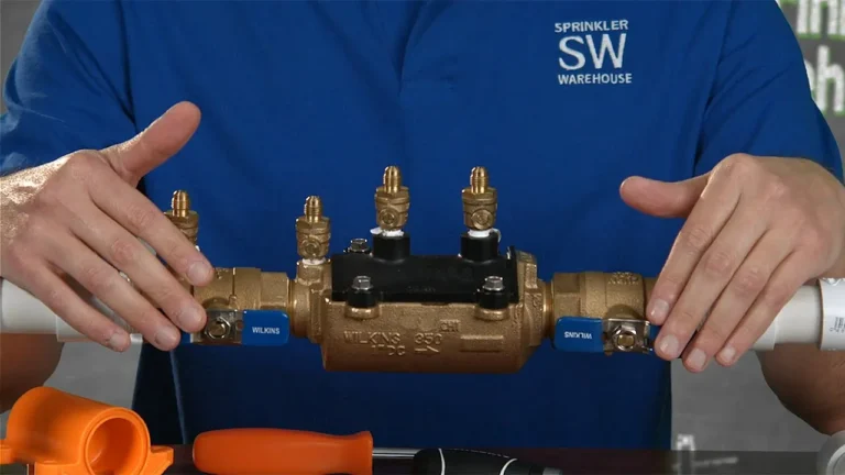 Man holding a brass backflow device.