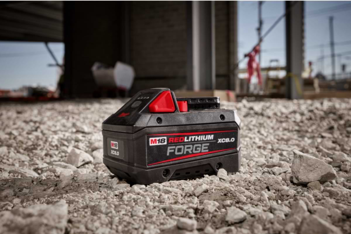 Maintenance 8 Milwaukee Tool M18 Redlithium battery resting on a gravel rock bed.