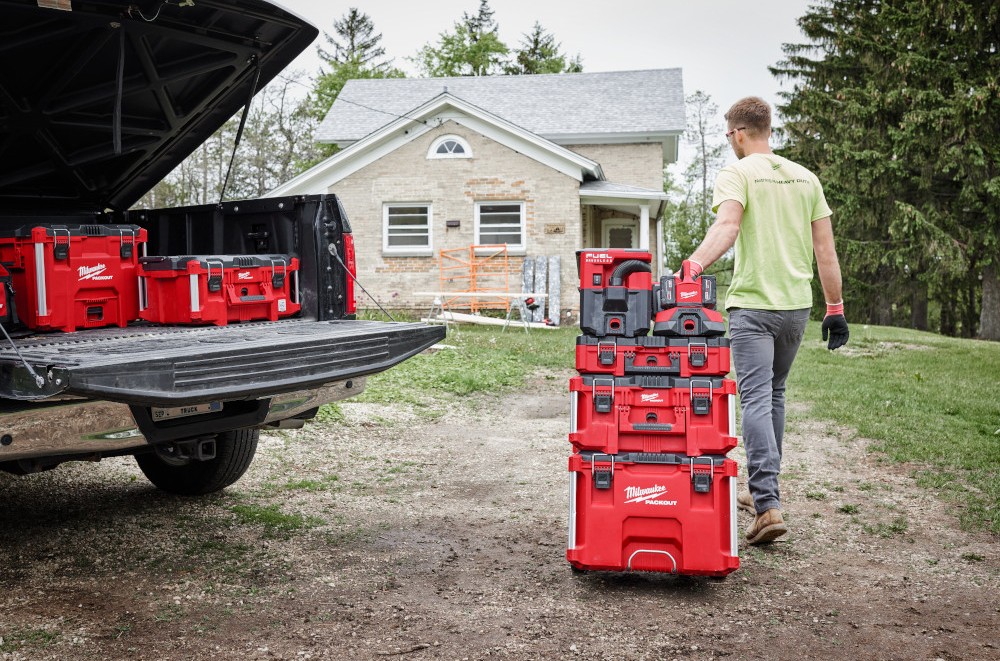 Milwaukee PACKOUT™ Guide: Work Smarter with Milwaukee Box Tools 3 Man rolling stacked Milwaukee PACKOUT storage chests.