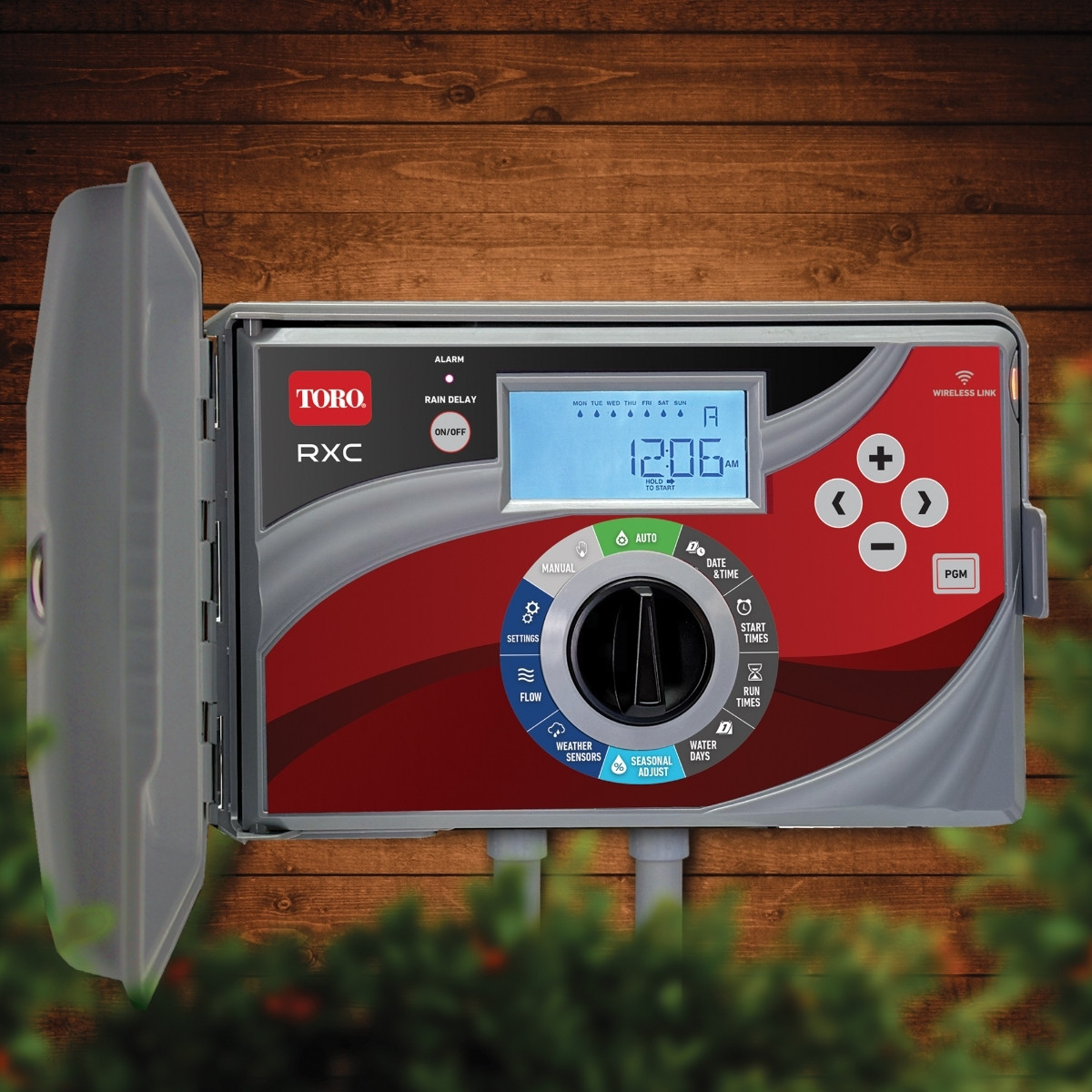 Toro RXC controller mounted against a wood exterior with bushes in the foreground.